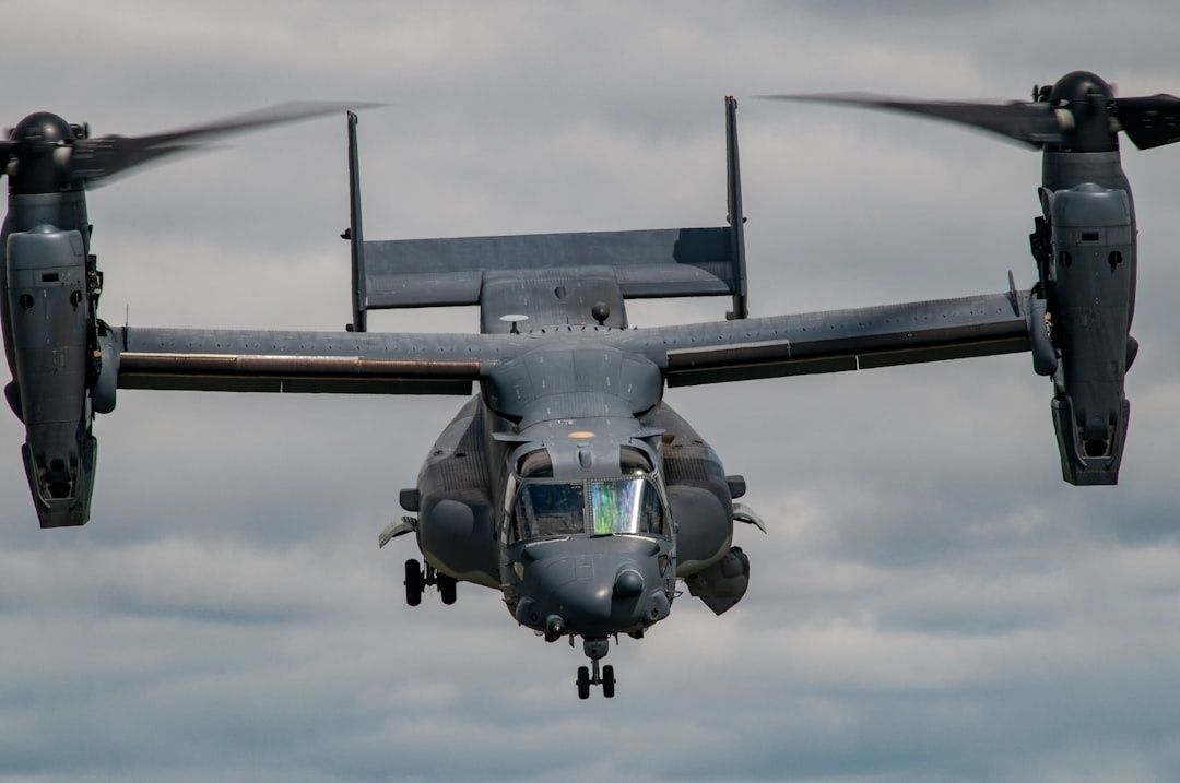 Militært tiltrotorfly sett forfra i luften med propellene i rotasjon